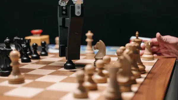 Robotic arm playing chess with a human, illustrating stop AI from rewriting existing code concept